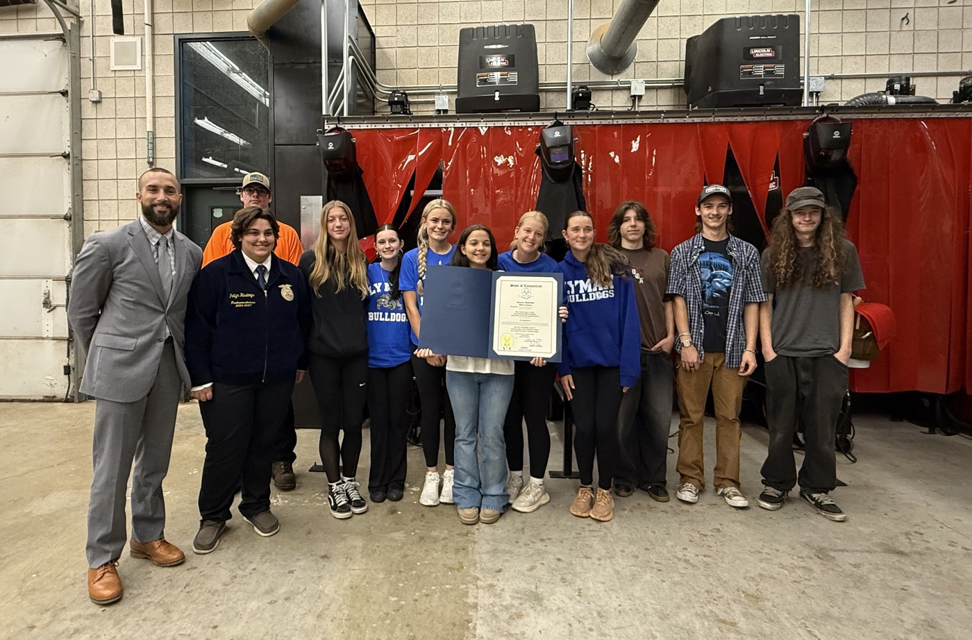 Lebanon Public Schools’ photograph from the September 29, 2026 celebration of Lyman Memorial High School’s Welding Pathway shows a group holding a legislative citation inside the welding lab.